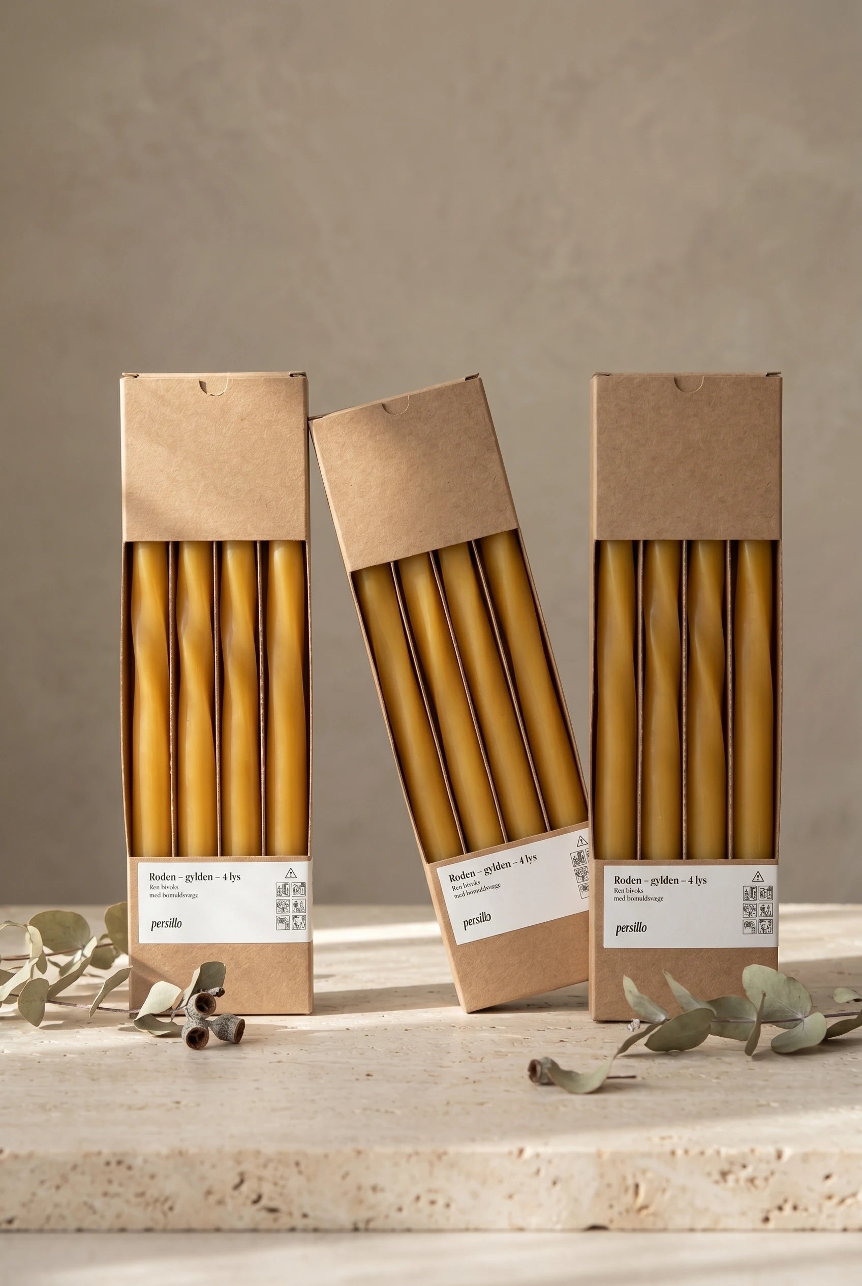 Flere pakker Roden Gylden bivokslys i kraftpapirsemballage med eucalyptus