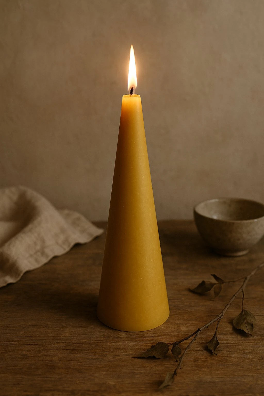 Grankoglen keglelys i gylden 100% bivoks fra Persillo – håndstøbt naturligt lys med lang brændetid på ca. 85 timer, stående på rustikt træbord.